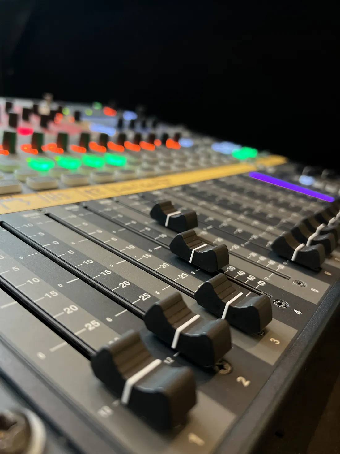 Nahaufnahme der Fader eines digitalen Mischpults