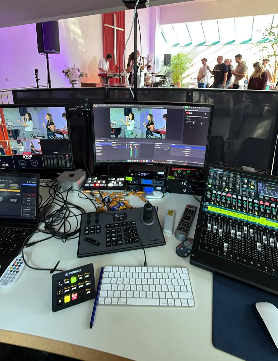 Streaming-Regie mit Bildmischer, Vorschau-Monitoren, Kamerasteuerung und PTZ-Kamera vor dem Saal
