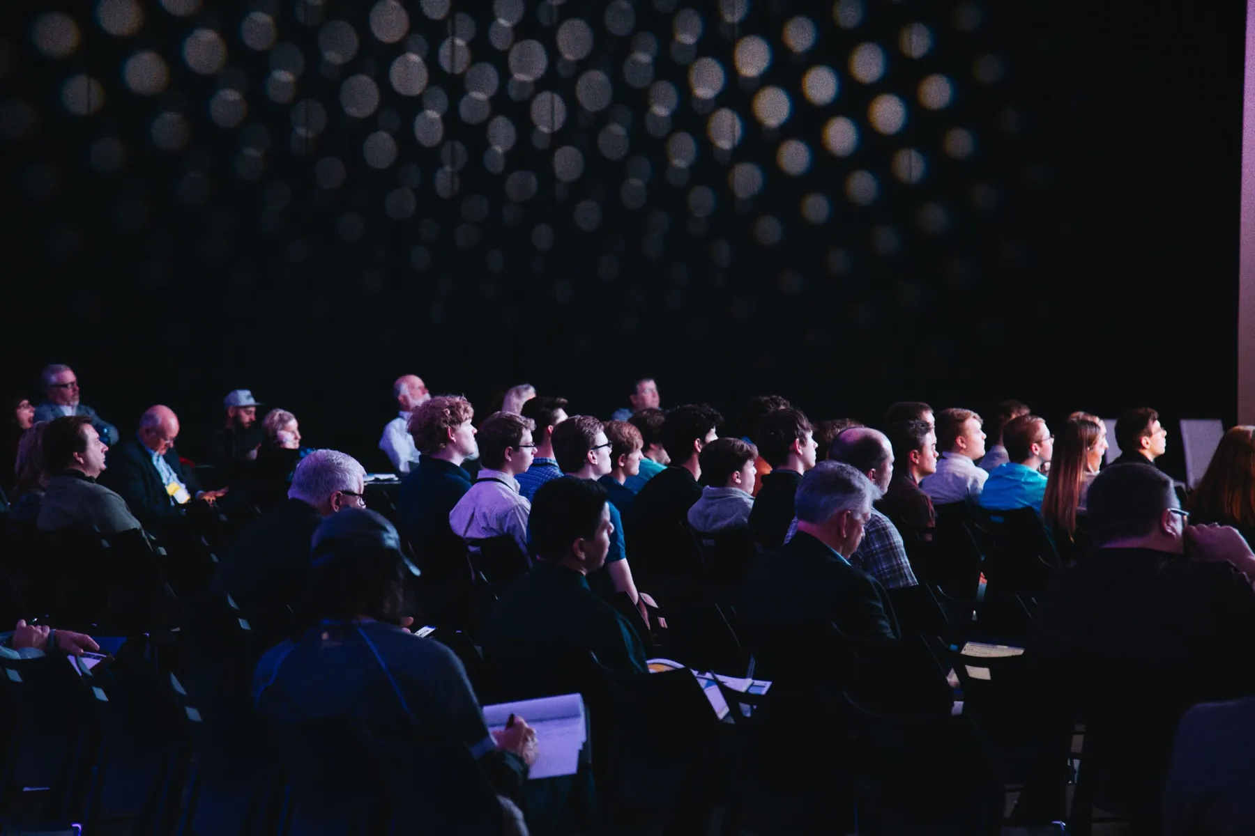 Publikum in einem abgedunkelten Konferenzsaal