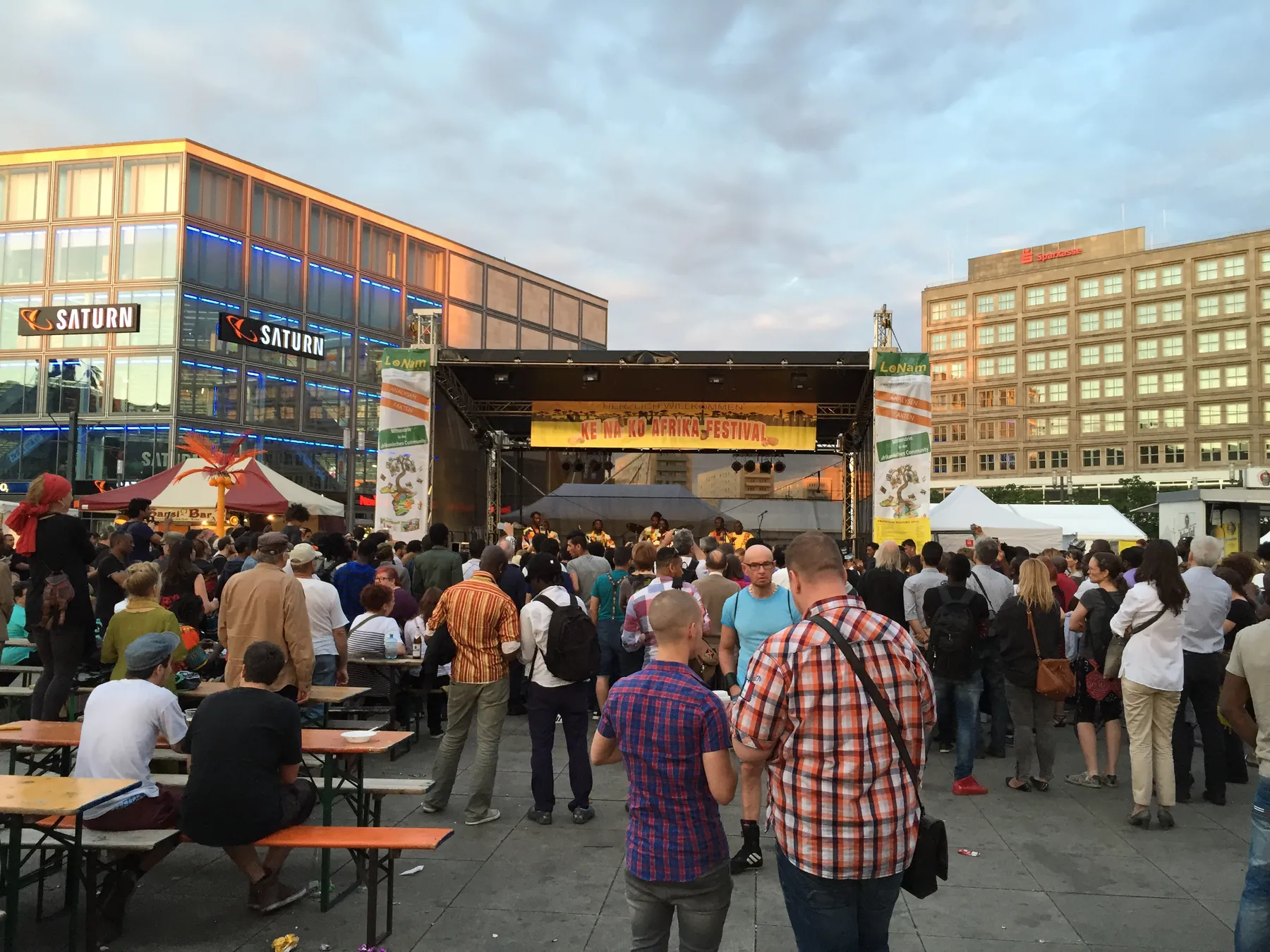 Open-Air-Bühne am Alexanderplatz mit Publikum an Biertischen